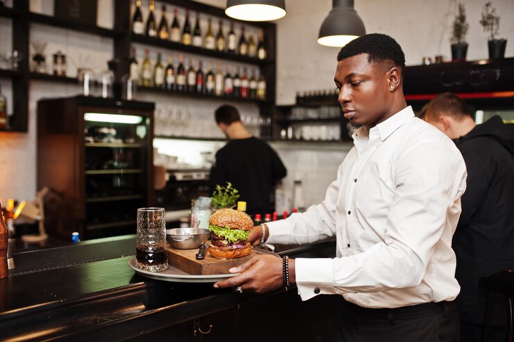 young-african-american-waiter-man-hold-tray-with-burger-bar-restaurant_627829-13240.jpg